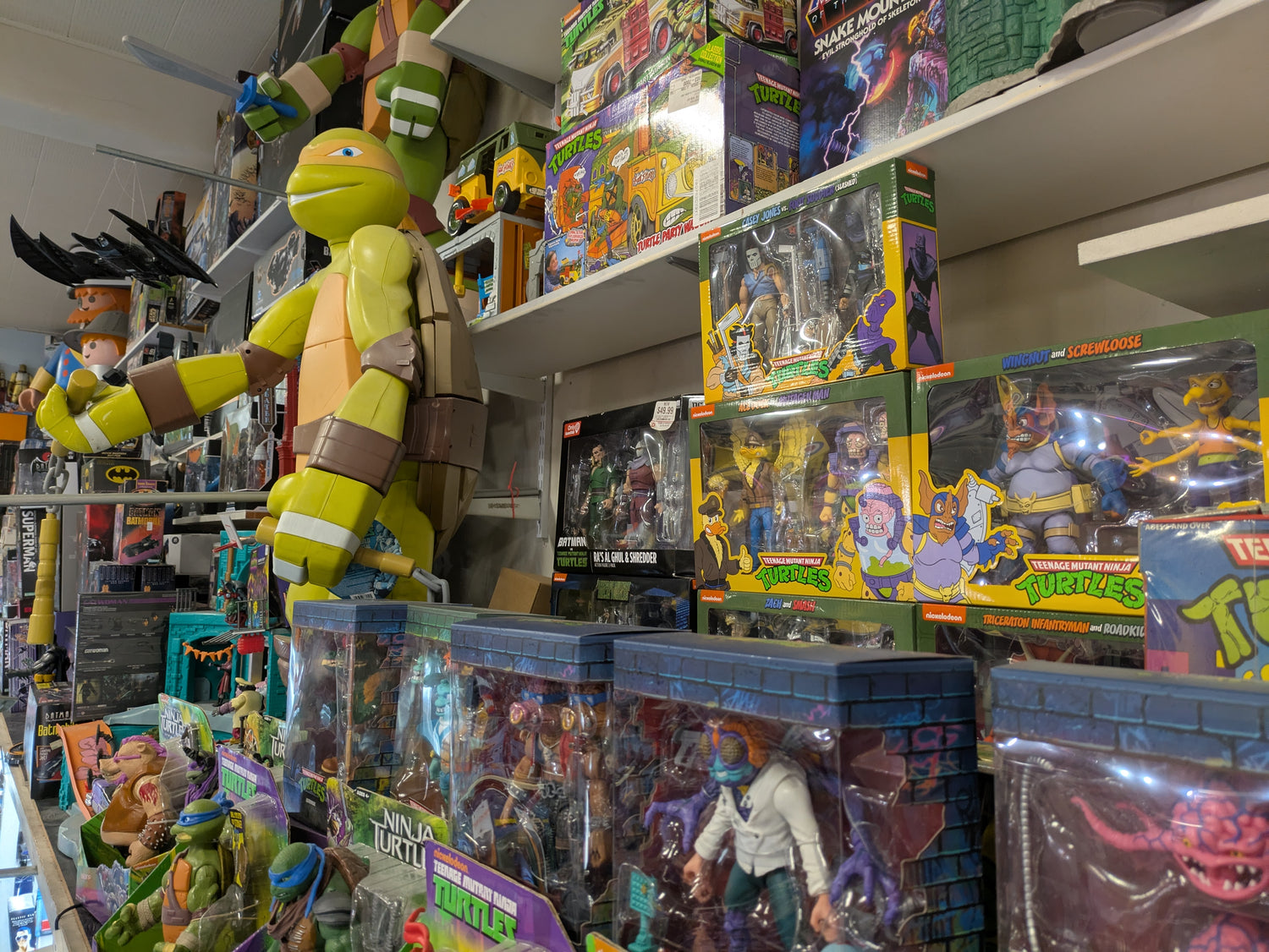 Shelf with action figures and packaging in a store setting