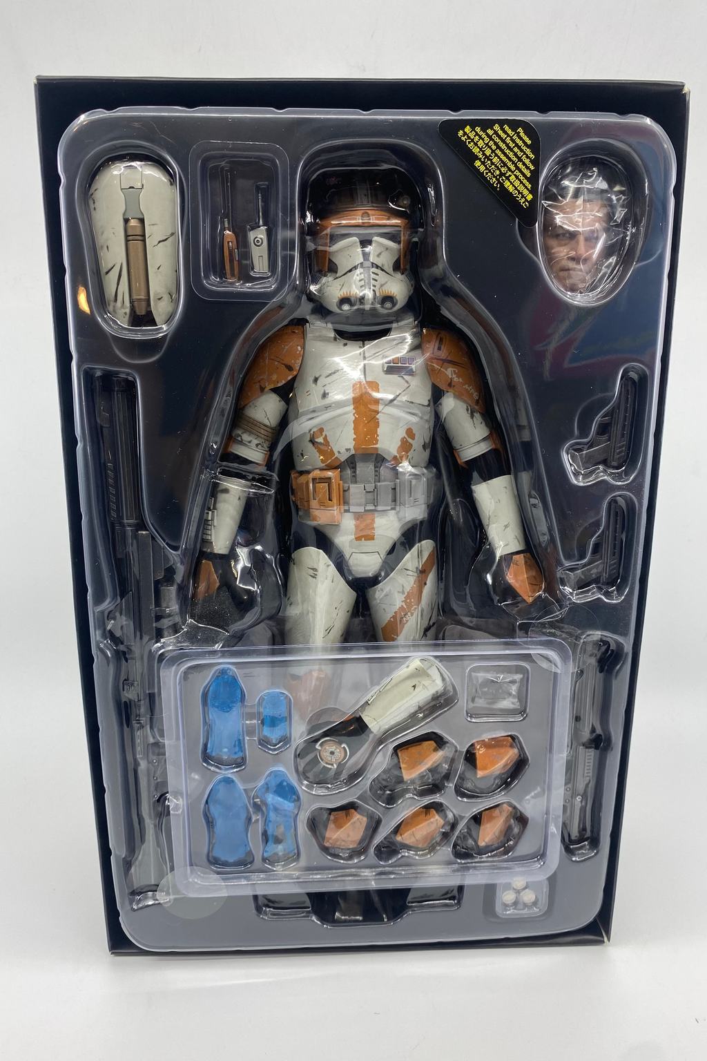 Action figure in packaging with accessories on a white background