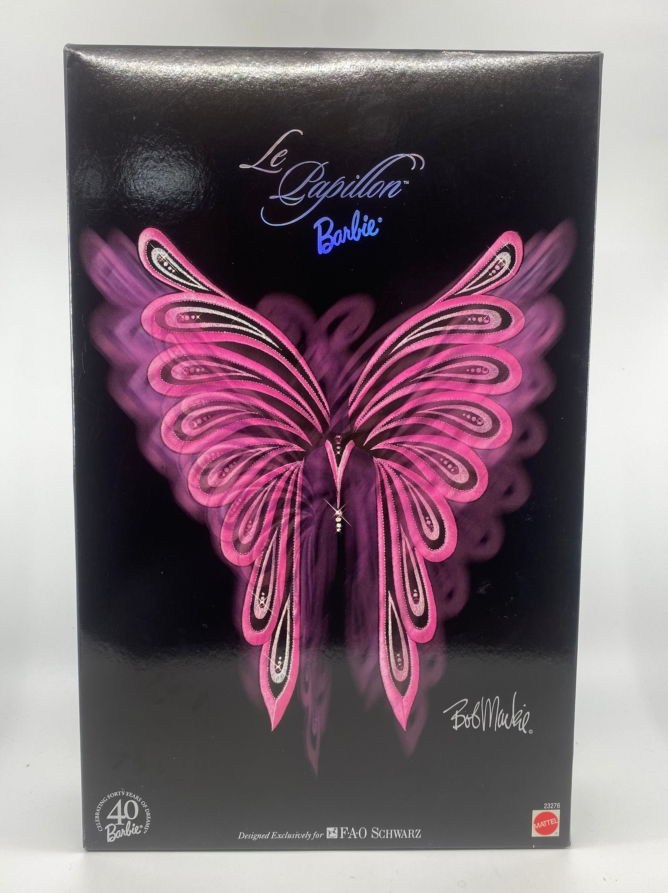 Barbie doll packaging with pink butterfly wings on a black background