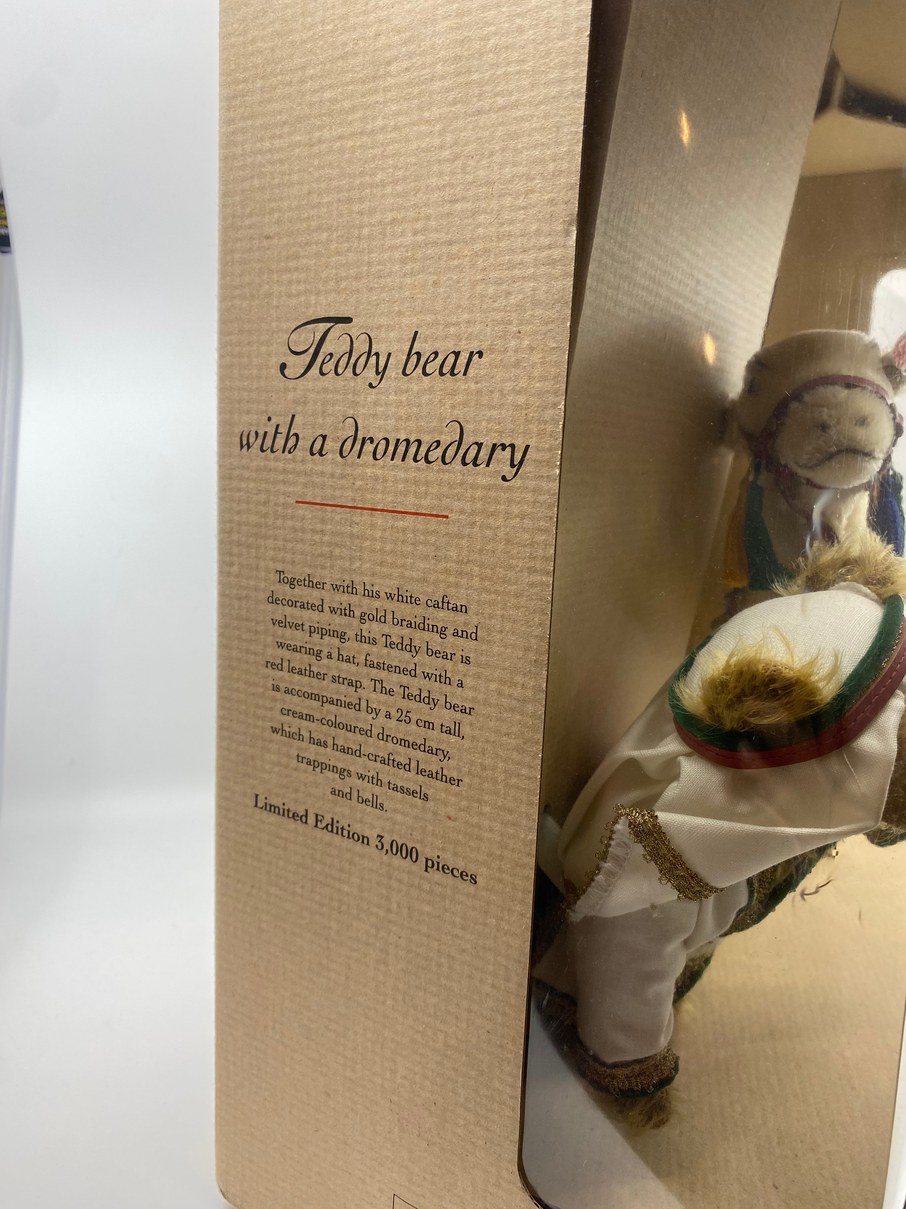 Teddy bear with a dromedary toy and packaging with text
