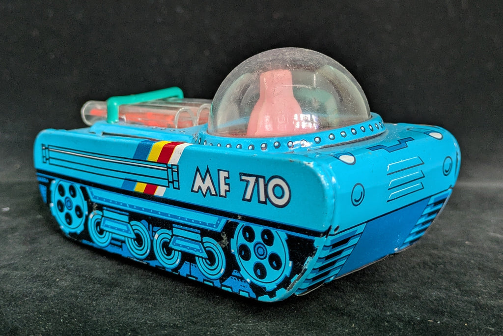 Toy robot with blue body and transparent dome on a dark background