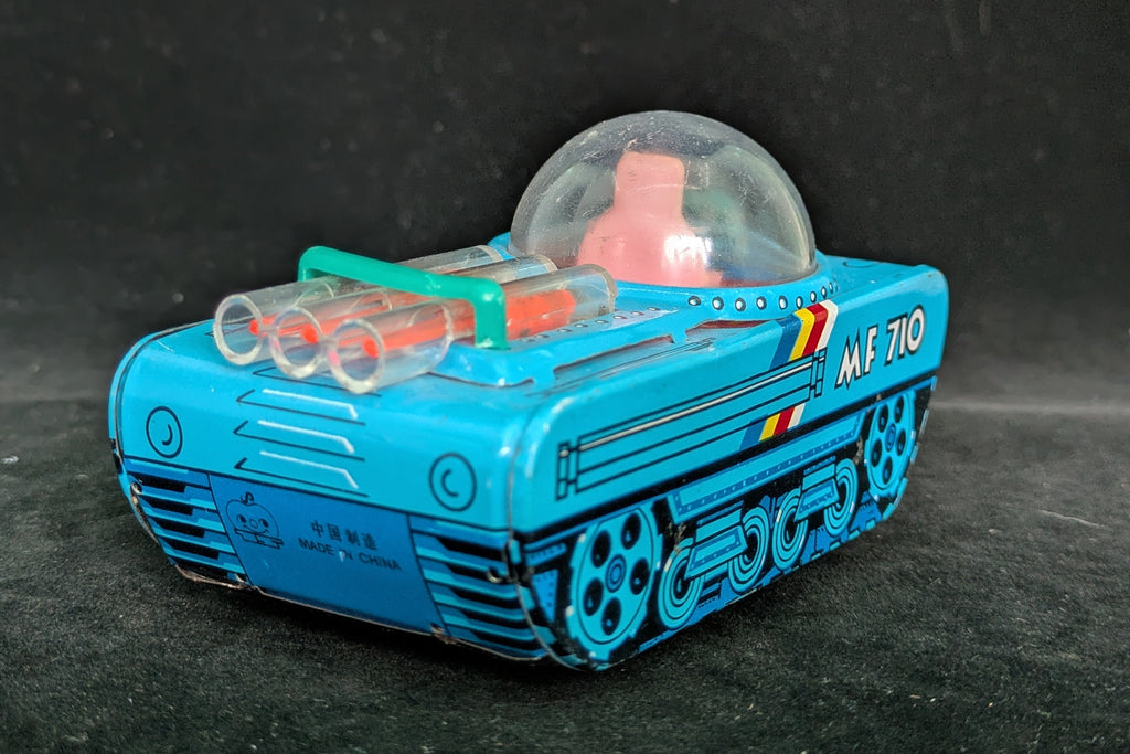 Toy vehicle with a blue body and transparent dome on a dark background