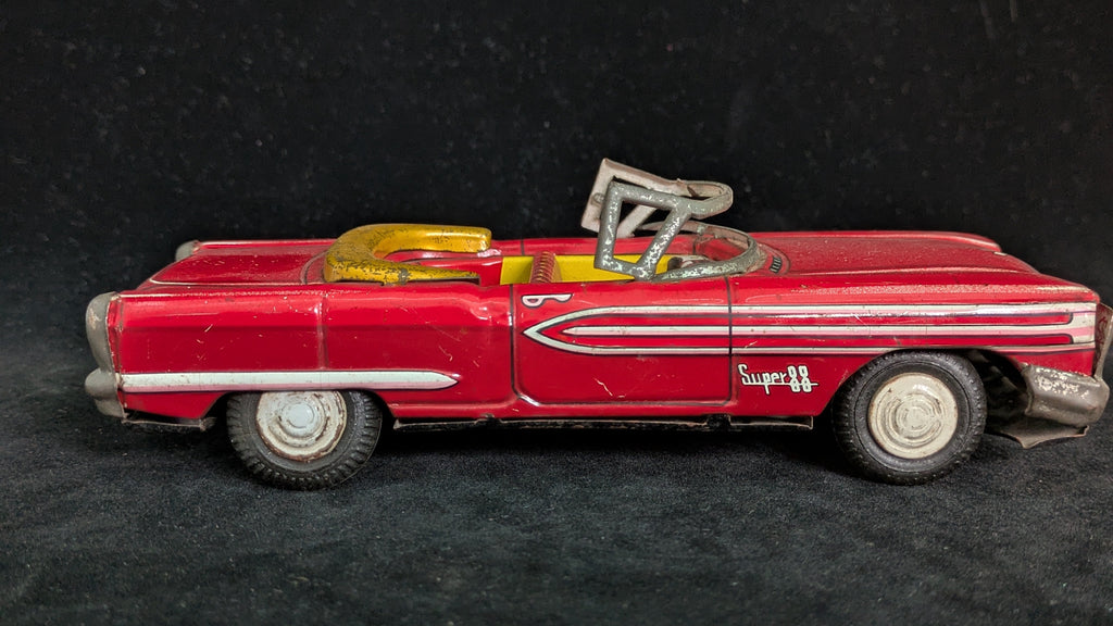 Red toy convertible car with a black background