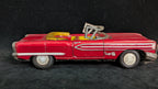 Red toy convertible car with a black background