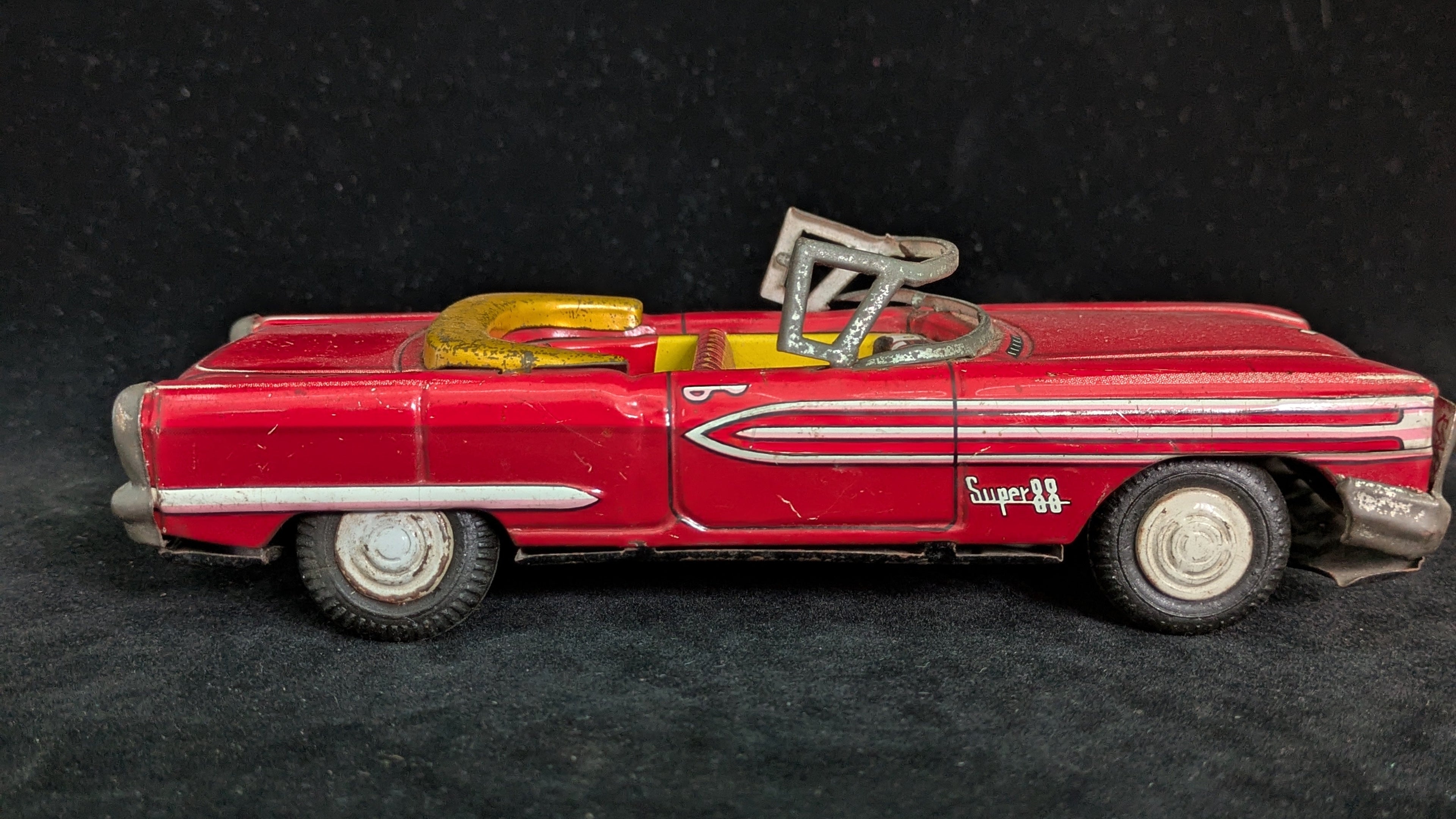 Red toy convertible car with a black background