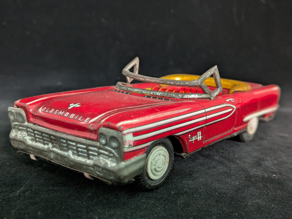 Red toy car with chrome details on a black background