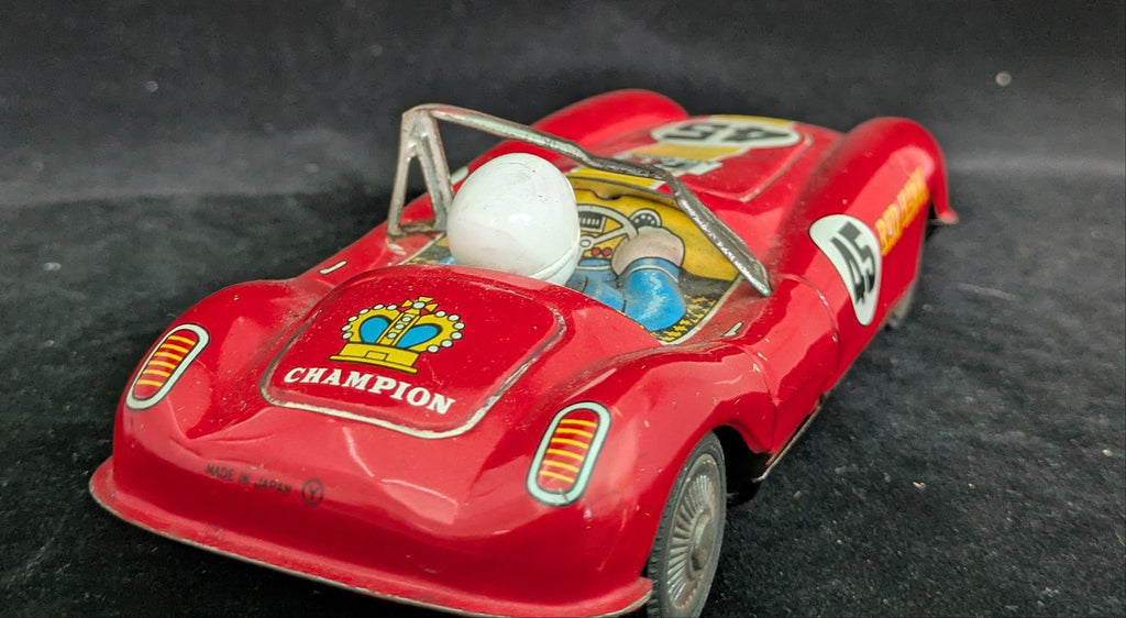 Red toy car with 'Champion' branding on a dark background