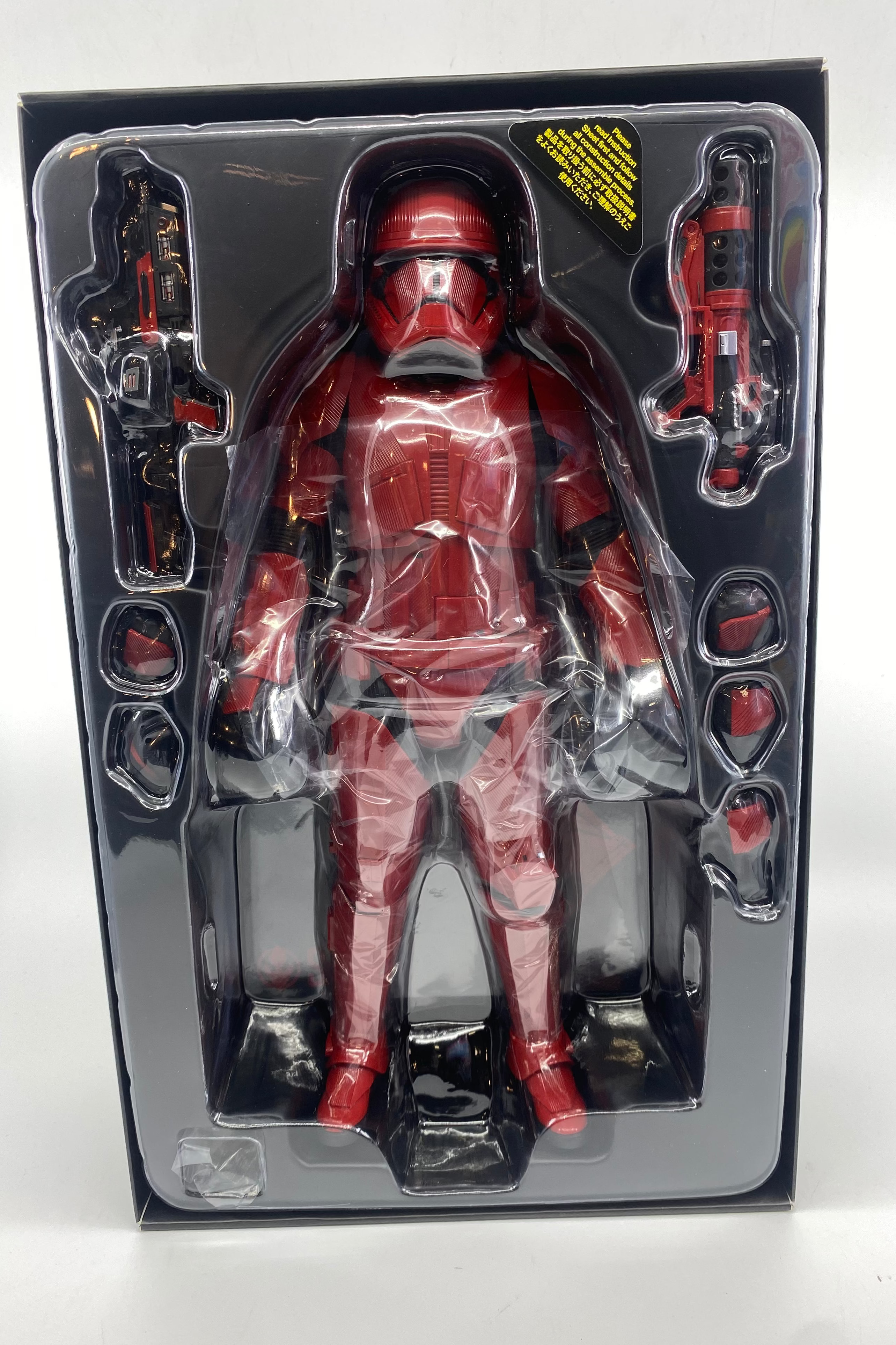 Red action figure in clear packaging on a white background