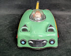 Small green toy car with a clear dome on a dark background