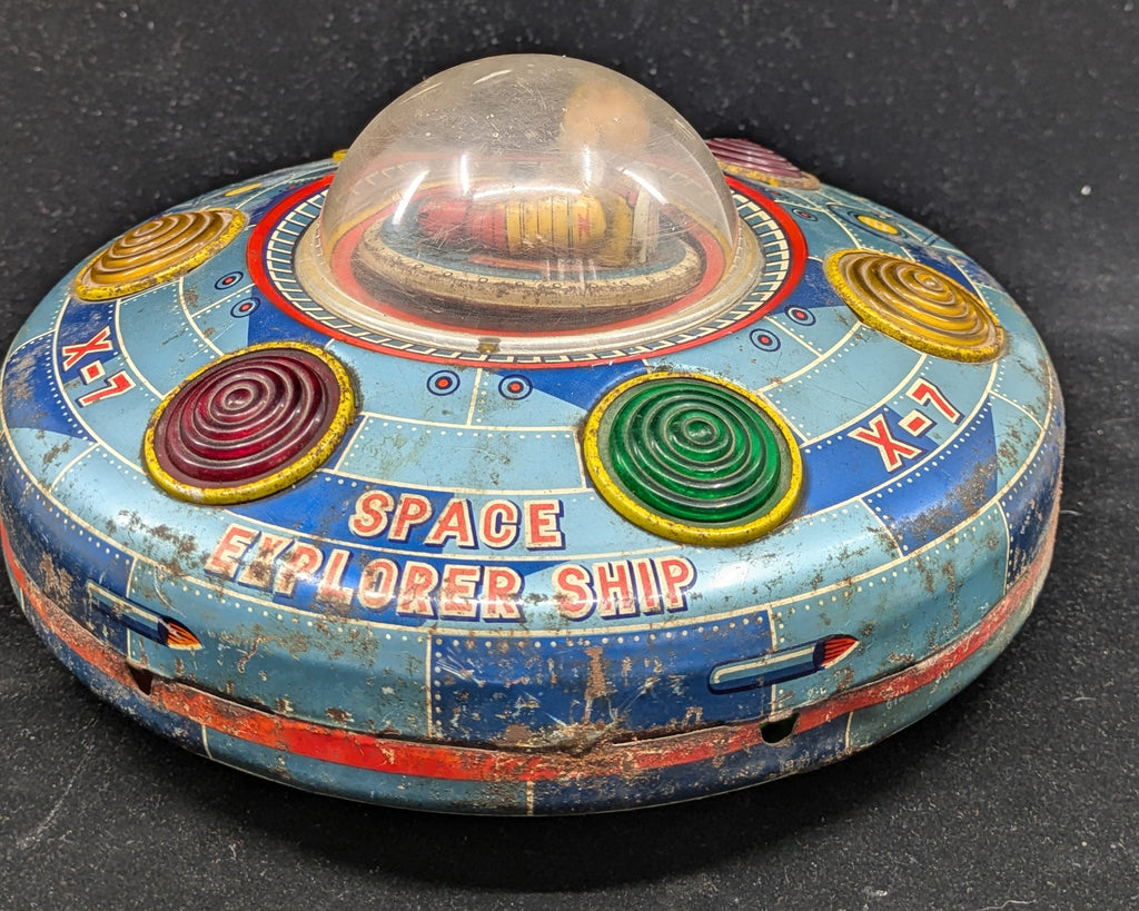Vintage toy space explorer ship on a black background