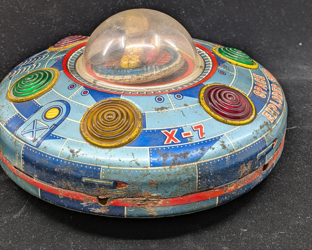 Vintage toy UFO with colorful design on a black background