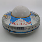 Toy resembling a UFO with 'X-80 Planet Explorer' text on a white background