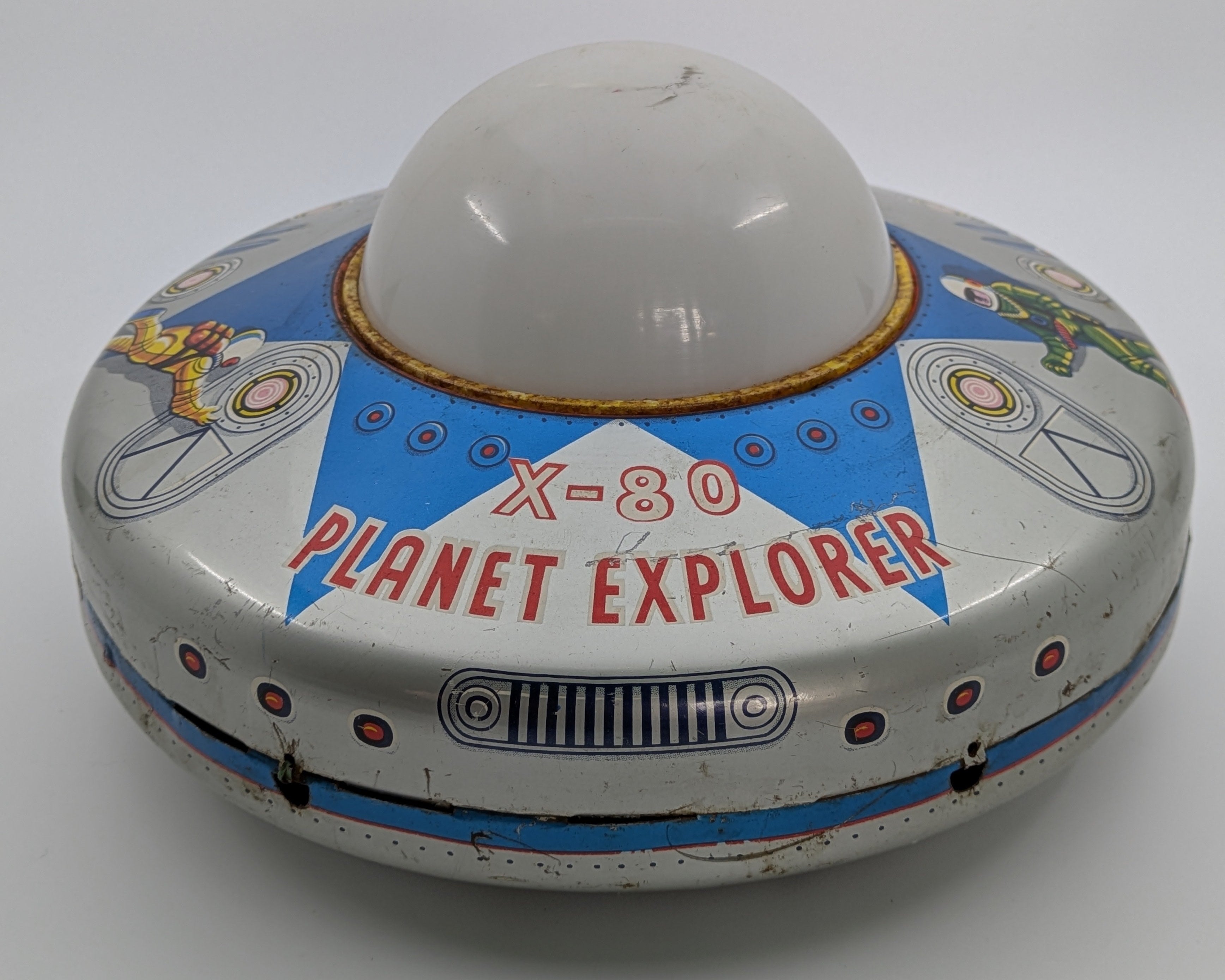 Toy resembling a UFO with 'X-80 Planet Explorer' text on a white background