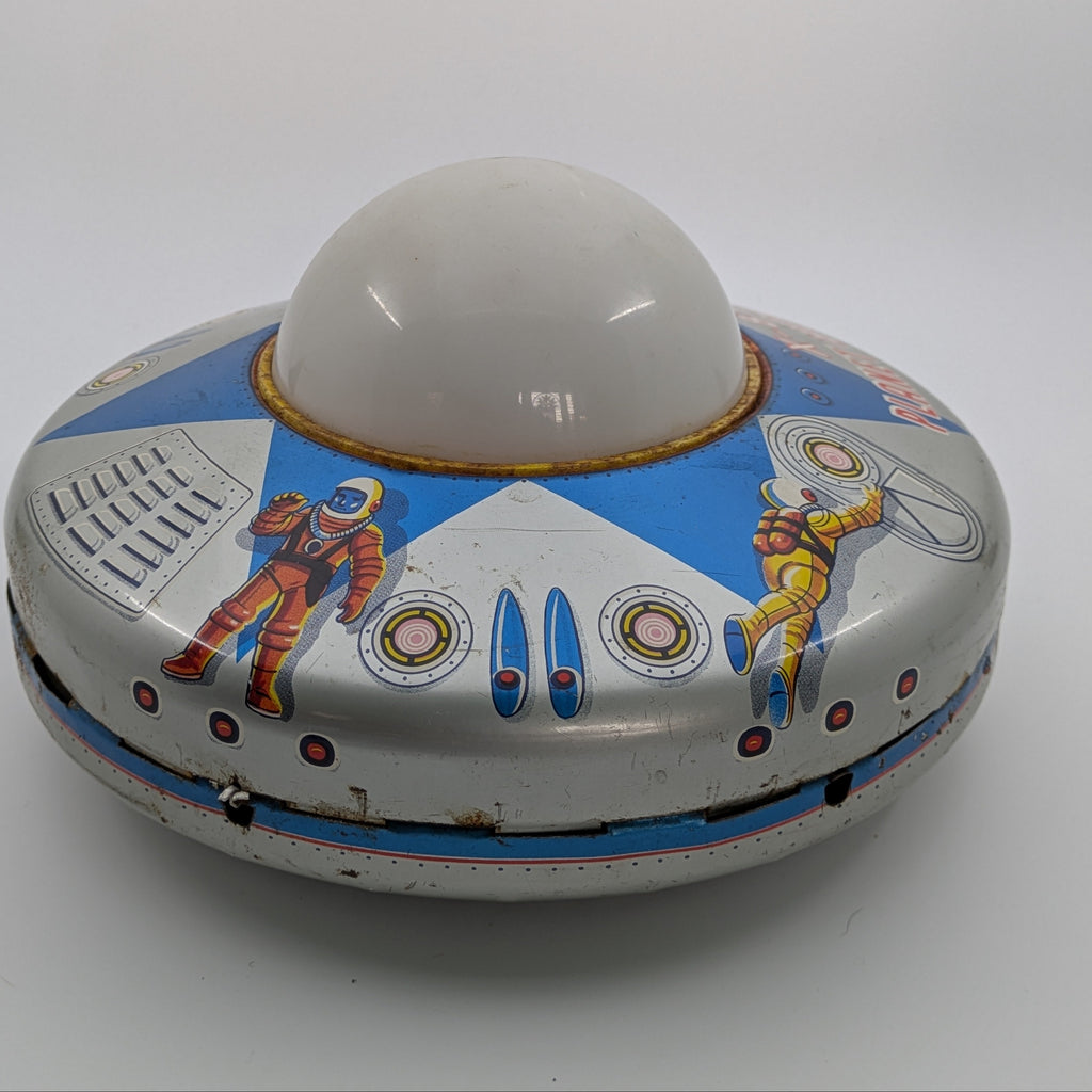Vintage toy UFO with colorful design on a white background